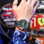 Reloj Ofsn para hombre con correa de silicona verde y dial multifunción, visto en primer plano sobre una camisa azul brillante.
