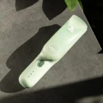 Cortadora de cabello VGR para bebé color verde menta con diseño ergonómico, botón de encendido, indicador de carga y logo visible sobre superficie gris.