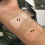 Prueba de dos tonos de base cushion sobre la piel del antebrazo: el tono 1 presenta un matiz claro rosado y el tono 2 un matiz medio cálido y bronceado.