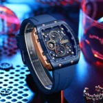 Reloj Curren 8442 con caja rectangular azul y bisel en tono oro rosa, esfera cronógrafo texturizada, manecillas luminiscentes y correa de silicona azul.