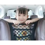 Niña sonriente en un carro sentada detrás de organizador de malla negra para asientos.