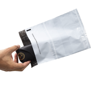 Mano inserta estuche de lentes Ray-Ban negro en bolsa de envío blanca con sello adhesivo.