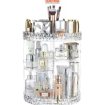 Organizador de maquillaje giratorio de acrílico transparente con botellas de perfume y brochas.