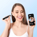 Mujer sonriente usa limpiador de oídos con cámara, se muestra en smartphone.