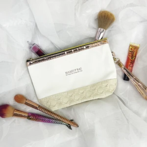 Bolso organizador de maquillaje blanco con detalles dorados y texturizados, incluye pinceles y brillo labial.