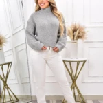 Suéter dama cuello alto gris tejido, pantalón blanco, sandalias plateadas.
