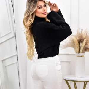 Suéter negro cuello alto para dama, talla única, con jeans blancos.