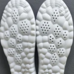 Plantillas viscoelásticas blancas para zapatos con diseño de burbujas y orificios de ventilación en la suela.