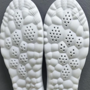 Plantillas viscoelásticas blancas para zapatos con diseño de burbujas y orificios de ventilación en la suela.