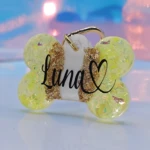 Placa de mascota de resina con forma de hueso color amarillo y dorado, personalizada con nombre "Luna" y un corazón.