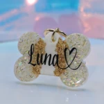 Placa para perro personalizada con nombre "Luna" y corazón, diseño de hueso con escarcha dorada y brillos.