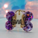 Placa de mascota en forma de hueso morada con glitter y nombre "Luna" en dorado.