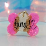 Placa para perro personalizada "Luna" con corazón, forma de hueso, color rosa brillante y detalles dorados.