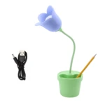 Lámpara de escritorio LED con forma de tulipán azul y base verde tipo maceta, incluye cable de carga USB y portalápices con un lápiz amarillo insertado.
