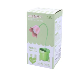 Lámpara LED modelo LD3059 con diseño de flor rosa, cuello flexible de silicona y base verde tipo matera organizadora, presentada en empaque de cartón.