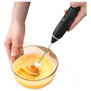 Batidora eléctrica V-25 negra batiendo líquido amarillo en un tazón de vidrio.