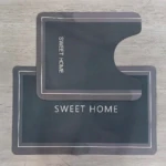 Tapetes duo absorbentes gris oscuro con borde blanco y texto "SWEET HOME".