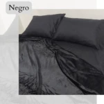 Cobija piel de durazno negra, tamaño 1.40, textura suave y mullida, con dos almohadas negras encima.