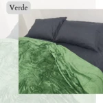 Cobija piel de durazno verde sobre cama con almohadas grises. Textura suave y mullida.