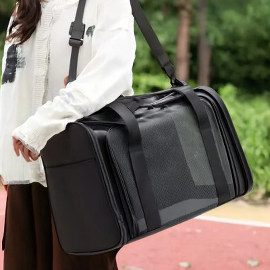 Maleta transportadora negra plegable para mascotas, con ventanas de malla transpirable y correas de hombro y mano.