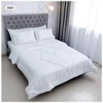 Edredón doble faz blanco para cama doble con diseño acolchado lineal y capitoné en cabecero gris.