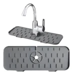 Alfombrilla protectora de silicona gris para grifo de cocina con diseño antideslizante, presentada en vista superior e instalada alrededor de un grifo.