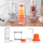 Dispensadores de aceite transparentes con brochas de silicona naranja y rosa, uno con líquido amarillo y otro con líquido marrón.