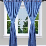 Cortina jacquard azul con patrón de círculos y ojales decorativos.