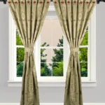 Cortinas jacquard beige con diseño circular, atadas a los lados, decoran una ventana doble con vista a árboles verdes.