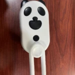 Cepillo para mascotas tipo panda con vapor, blanco y negro, con brazo articulado de sujeción.