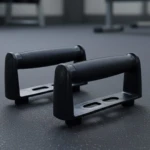 Soportes para flexiones negros con mangos texturizados, sobre superficie gris texturizada.