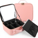 Cosmetiquera rosa abierta con espejo LED, divisores internos ajustables y estuche de brochas extraíble.