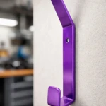 Gancho morado metálico para colgar casco de moto en pared.