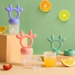 Dos chupones para fruta de reno en morado y rosa, con recipientes transparentes, jugo y rodajas de cítricos.