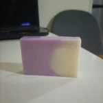 Jabón artesanal de avena y lavanda, barra bicolor lila y crema, con acabado suave.
