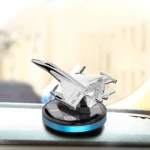 Ambientador solar para carro en forma de avión plateado, con base negra y detalles azules.