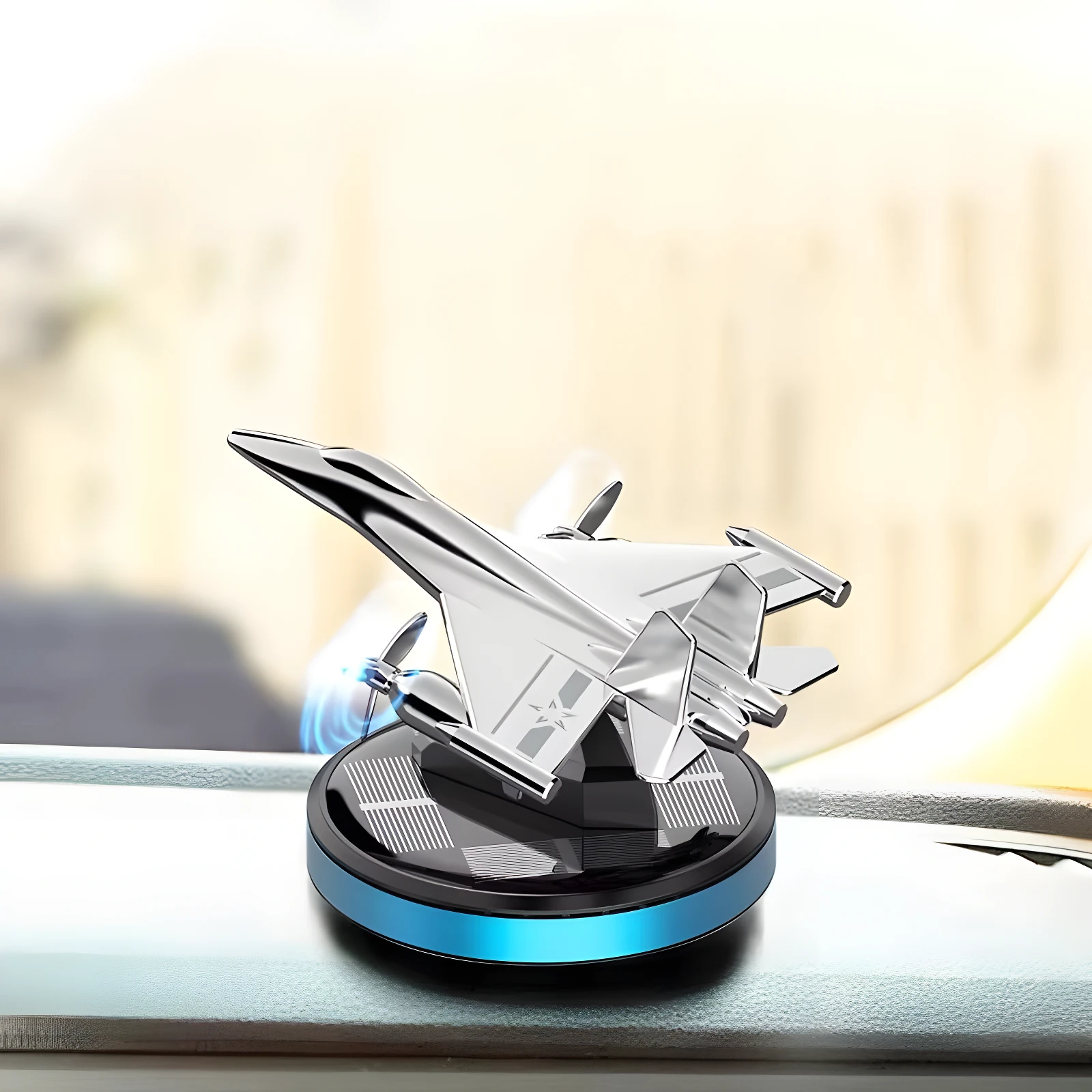 Ambientador solar para carro en forma de avión plateado, con base negra y detalles azules.