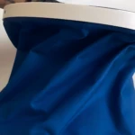 Balde plegable azul de tela texturizada, con borde blanco, útil para transportar agua.