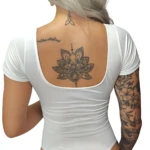 Body blanco manga corta poli licra, realza figura. Espalda con tatuajes de flor de loto y trébol.