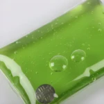 Bolsa gel reutilizable verde para termoterapia fría o caliente con burbujas y detalle metálico.