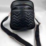 Bolso manos libres negro mujer con diseño acolchado en zigzag, dos compartimentos, correa ajustable y herrajes dorados.