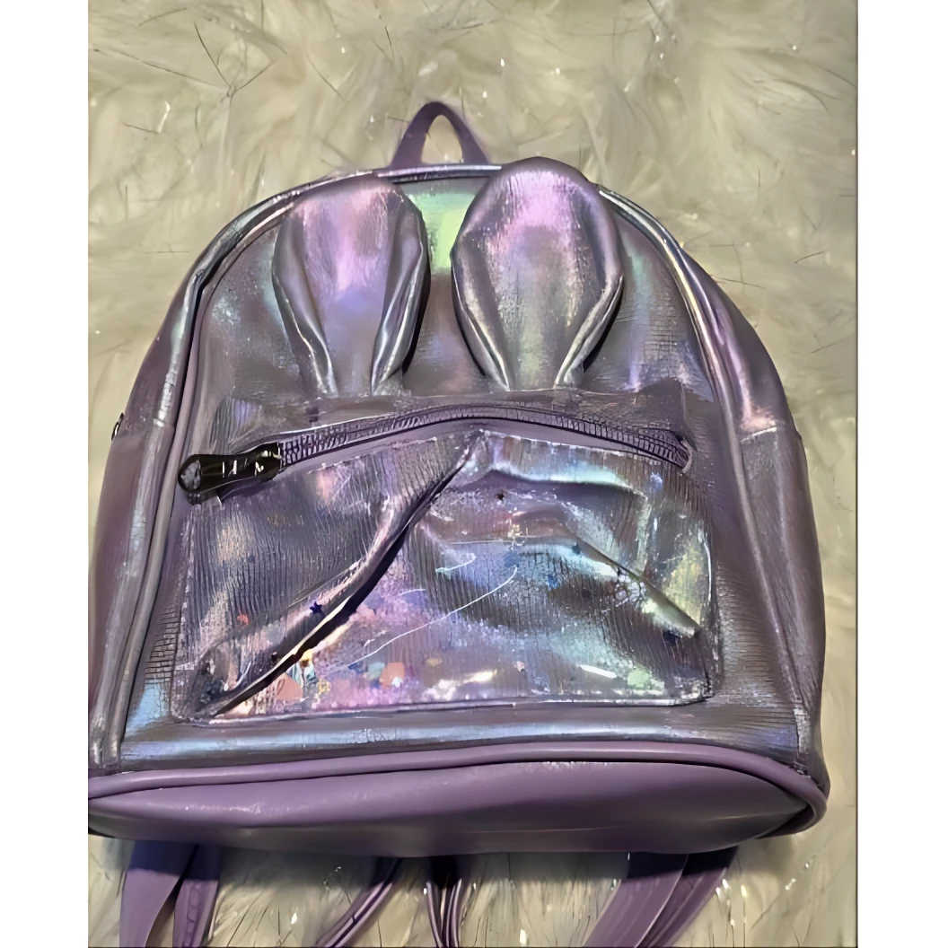 Bolso infantil metalizado morado con orejas de conejo y bolsillo transparente con confeti.