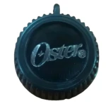 Botón negro Oster para licuadora con logo grabado y borde texturizado.