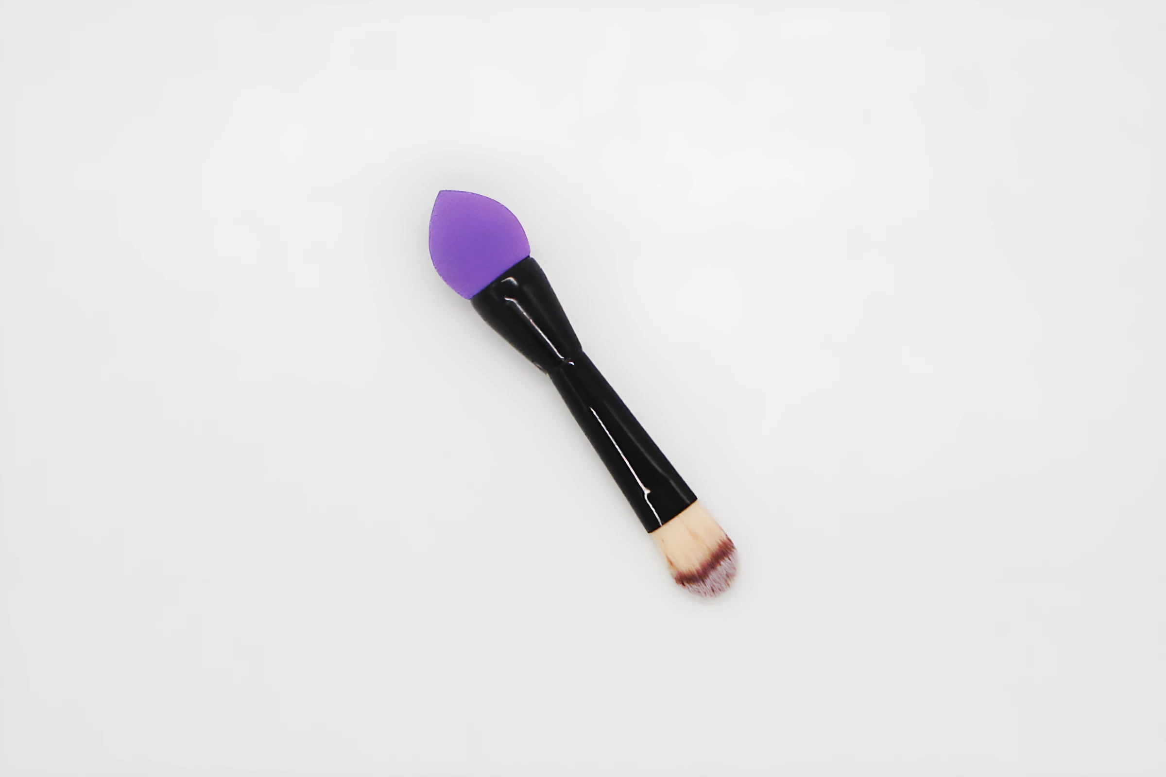 Brocha de maquillaje 2 en 1: punta de silicona morada y cerdas en degradado para base.