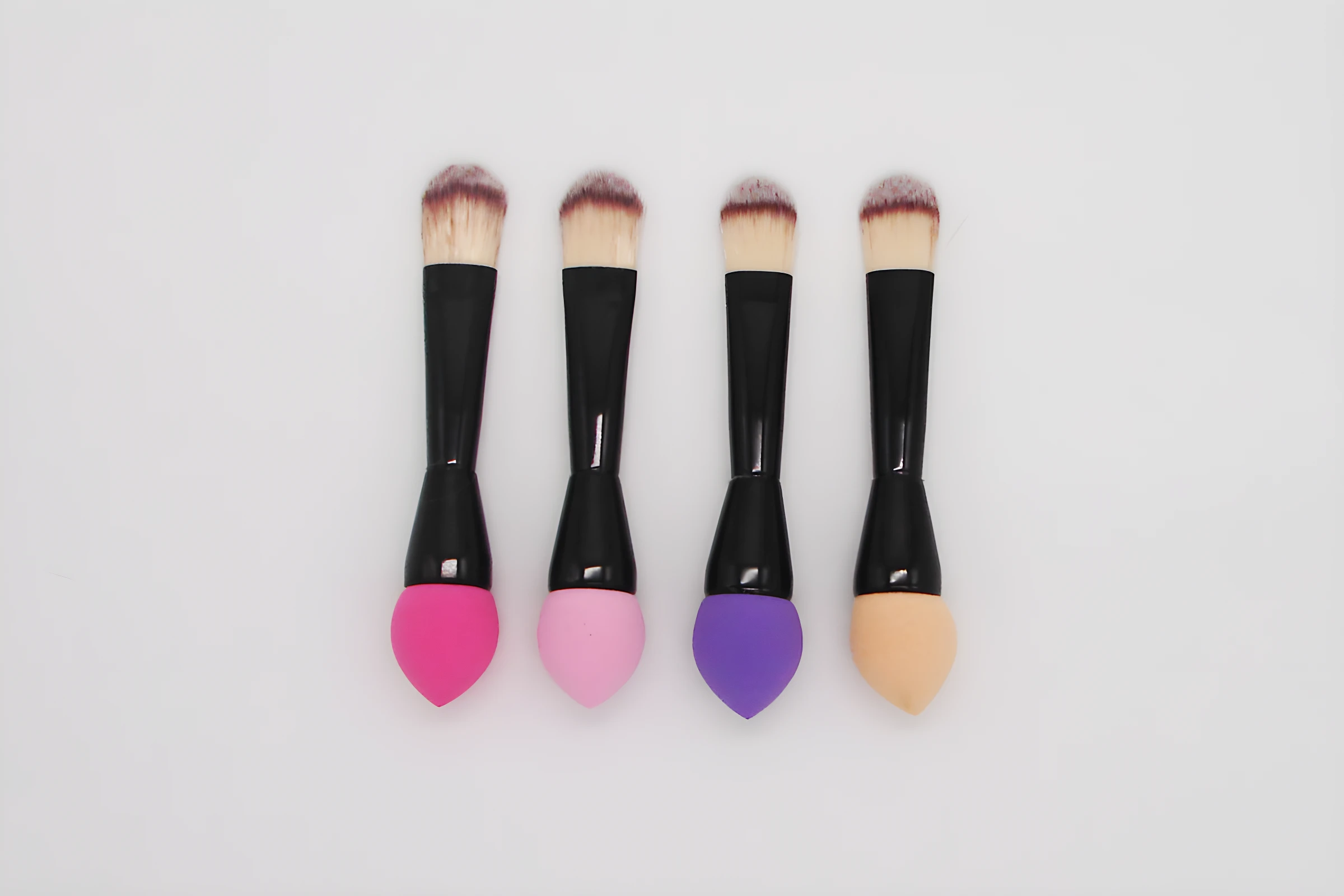 Set de 2 brochas de maquillaje 2 en 1 con extremo en esponja de colores: fucsia, rosa, morado y beige.