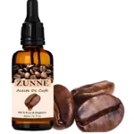 Frasco de vidrio ámbar con gotero de Aceite de Café Zunne de 30ml, etiqueta crema con granos de café y tres granos naturales dispuestos al frente.
