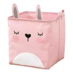 Canasta organizadora rosada con diseño de conejito, orejas y cara. Plegable, ideal para ordenar.