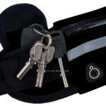Canguro deportivo negro con cremallera, detalles reflectantes y dos llaves para seguridad.