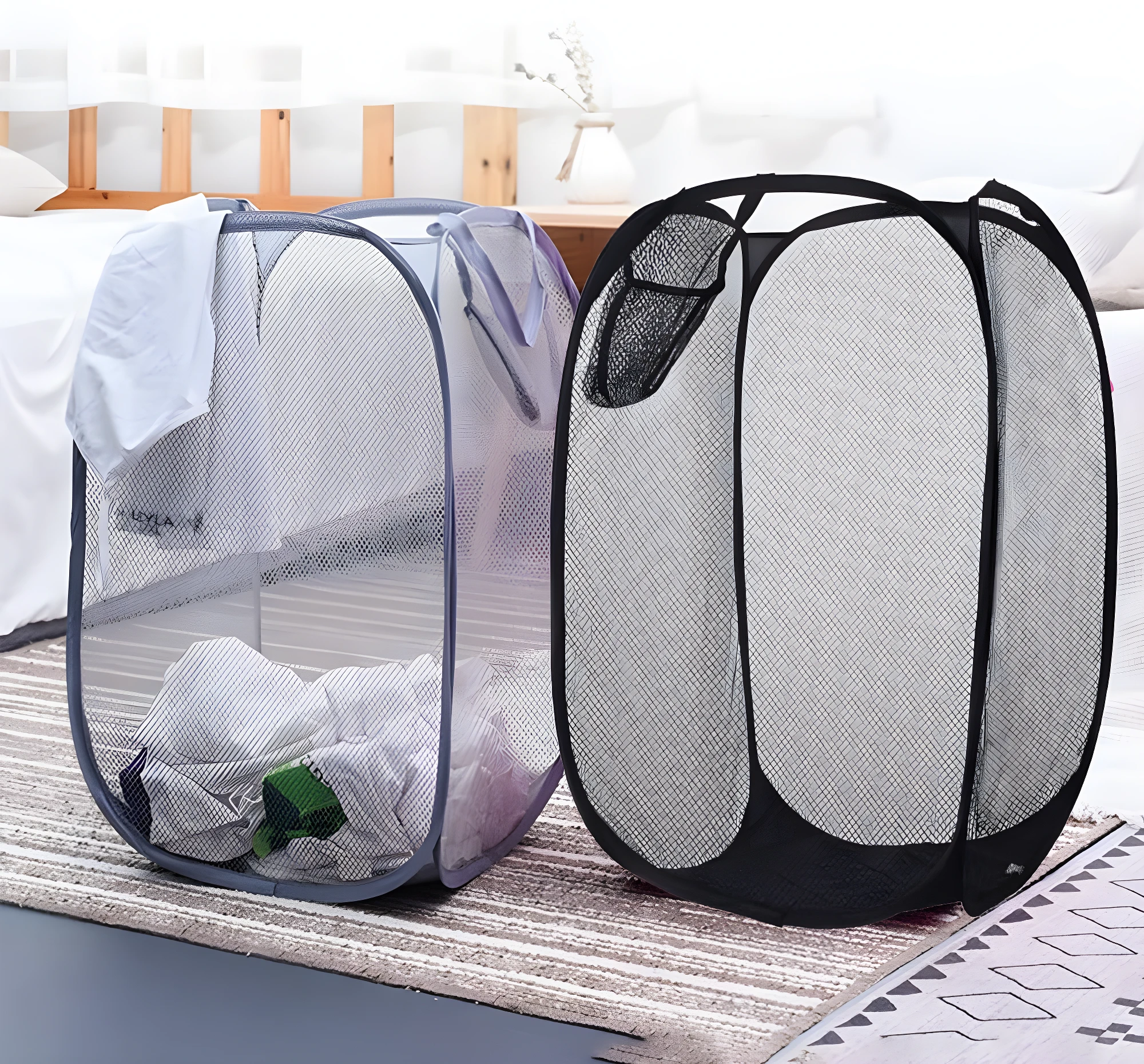 Cestas plegables de malla para ropa: una gris con ropa y otra negra vacía en una habitación.