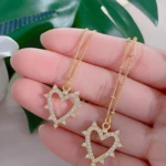 Set de 2 collares dorados para mujer, cadena fina con dije de corazón calado con circones.